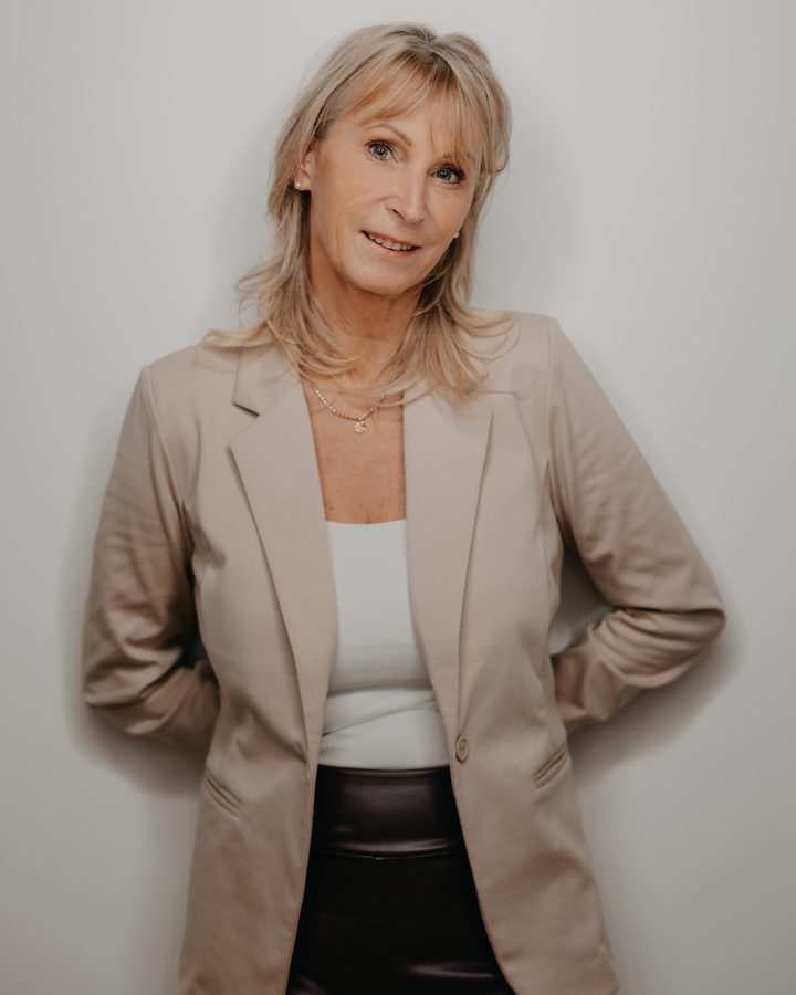 Sabine Gaiselmann, Inhaberin von Formschön, im hellen Blazer vor einer weißen Wand